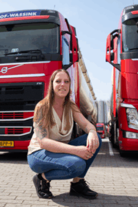Foto van Marianne Veenstra bij rode vrachtwagens